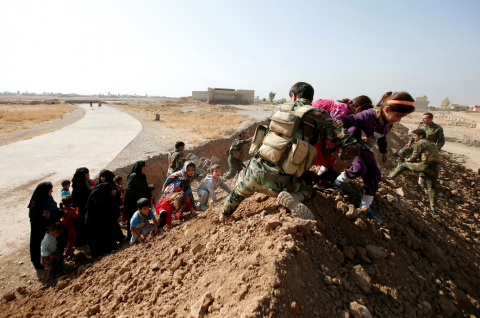 Soldati curdi aiutano la popolazione di Mosul a fuggire verso nord (Thomas Van Linge/Twitter).