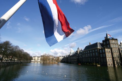 Dutch flag with the parliament buildings in the background; The Hague, Netherlands